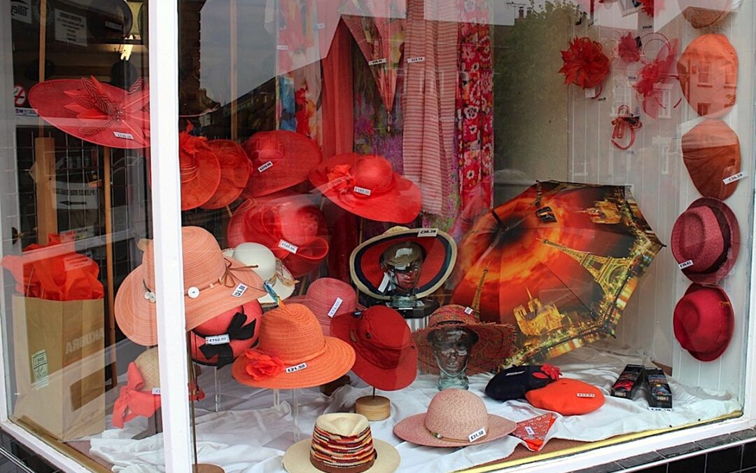 orange hats, fascinators & umbrellas in window display