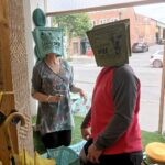 Readying display window at T Snook hat shop for 2023 Bridport Hat Festival