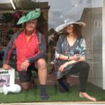 Readying display window at T Snook hat shop for 2023 Bridport Hat Festival