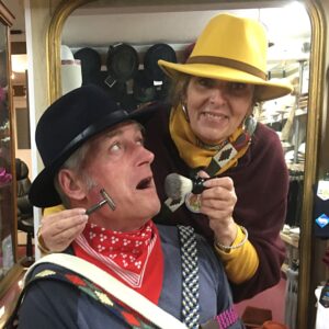 Demonstration of shaving gear, with belts and hats, at T Snook, hat shop in Bridport, Dorset