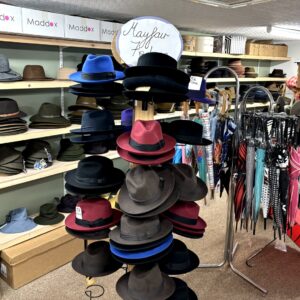 Winter hats and umbrellas in back room at T Snook, hat shop in Bridport, Dorset, England