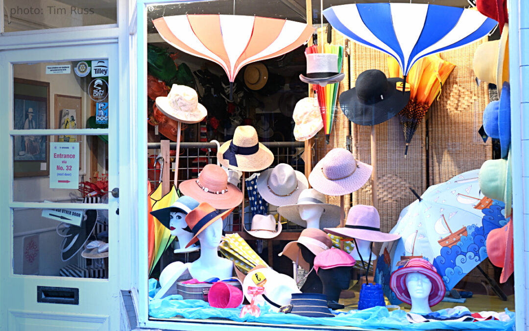 Beach-themed window for July 2025 at T Snook, hat shop in Bridport, Dorset, England