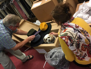 Roger & Sue with Tuppence the shop dog in a box, at T Snook, hatters of Bridport